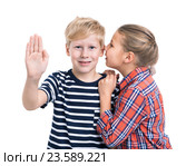 Мальчик смотрит в камеру с поднятой вперед ладонью, девочка шепчет на ухо, белый изолированный фон. Стоковое фото, фотограф Кекяляйнен Андрей / Фотобанк Лори