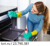 Smiling adult girl in gloves removing snuff in oven. Стоковое фото, фотограф Яков Филимонов / Фотобанк Лори