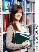 young female adult student with book in library. Стоковое фото, фотограф Дмитрий Калиновский / Фотобанк Лори