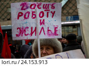 Женщинаидет на шествии КПРФ с плакатом "Даешь работу и жилье" в центре города Москвы, Россия (2016 год). Редакционное фото, фотограф Николай Винокуров / Фотобанк Лори