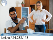 Blonde girl yelling at black boyfriend as quarreling indoors. Стоковое фото, фотограф Яков Филимонов / Фотобанк Лори