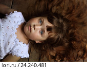 Задумчивая девочка лежит на полу. Стоковое фото, фотограф Марина Володько / Фотобанк Лори