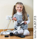 Little girl with socket extender and charging units indoors. Стоковое фото, фотограф Яков Филимонов / Фотобанк Лори