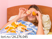 Счастливая девушка смешно приложила мандарины к глазам. Стоковое фото, фотограф Иванов Алексей / Фотобанк Лори