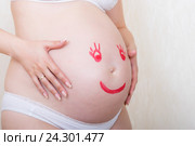 Беременная женщина с нарисованным на животе лицом. Стоковое фото, фотограф Андрей Некрасов / Фотобанк Лори
