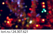 Holiday illuminated blurred Christmas lights and tinsel on black background. Стоковое видео, видеограф Юлия Зайцева / Фотобанк Лори