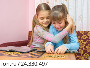Старшая сестра успокаивает плачущую младшую сестру, которая собирает стопку монет. Стоковое фото, фотограф Иванов Алексей / Фотобанк Лори