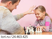 Папа выиграл в шахматы у дочки на спор и пробивает ей щелбан по лбу. Стоковое фото, фотограф Иванов Алексей / Фотобанк Лори