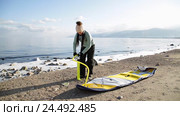 Девушка готовится плавать на sup board по зимнему озеру в Сибири. Озеро Байкал (2016 год). Редакционное видео, видеограф Виталий Зверев / Фотобанк Лори