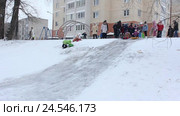 Дети катаются с ледяной горки. Игры в городе зимой. (2016 год). Редакционное видео, видеограф Мiлана Х / Фотобанк Лори