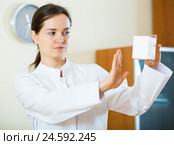 Serious female physician warning of faulty drugs. Стоковое фото, фотограф Яков Филимонов / Фотобанк Лори