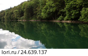 Спокойная гладь воды Биоградского озера с плывущей на веслах лодкой. Национальный заповедник. Черногория. Стоковое видео, видеограф Кекяляйнен Андрей / Фотобанк Лори