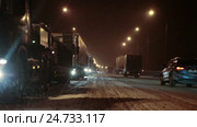 Ночной зимний затор на трассе М10 в сторону Москвы около Великого Новгорода. Грузовики стоят под снегопадом. Стоковое видео, видеограф Кекяляйнен Андрей / Фотобанк Лори