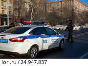 Инспектор ДПС производит проверку автомобилей около служебного автомобиля с включенным спецсигналом на набережной города (2017 год). Редакционное фото, фотограф Николай Винокуров / Фотобанк Лори