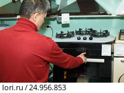 Мужчина проверяет работу газовой плиты (2017 год). Редакционное фото, фотограф Акиньшин Владимир / Фотобанк Лори