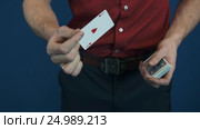 Close up illusionist in red shirt showing playing cards magic focuses. Стоковое видео, видеограф Александр Багно / Фотобанк Лори