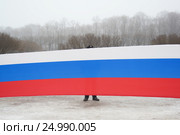 Мужчина стоит за транспарантом с российским триколором на митинге (2017 год). Стоковое фото, фотограф Иван Козлович / Фотобанк Лори