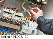 electrician examining current voltage with screwdriver tester. Стоковое фото, фотограф Дмитрий Калиновский / Фотобанк Лори