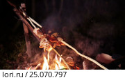 Roast meat on a stick over a campfire roasting directly. Стоковое видео, видеограф Сергей Кальсин / Фотобанк Лори