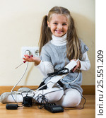 Little girl with socket extender and charging units indoors. Стоковое фото, фотограф Яков Филимонов / Фотобанк Лори