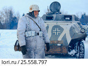 Деревня Нелидово, разъезд Дубосеково, Россия - 22 января 2017 года: Военно-историческая реконструкция "Поле боя. Горячий снег", посвященная оборонительным боям Красной Армии в полосе 1-го Украинского фронта (1944 год). Немецкий офицер в зимнем камуфляже на фоне полугусеничного бронетранспортёра Sd.Kfz. 251. Редакционное фото, фотограф Мария Москвицова / Фотобанк Лори
