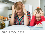 Woman with paperwork and girl in the kitchen. Стоковое фото, фотограф Яков Филимонов / Фотобанк Лори