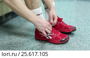 Спортсмен обувается в комнате для переодевания, кроссовки крупным планом (2015 год). Редакционное видео, видеограф Артём Крылов / Фотобанк Лори