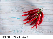 Red chili pepper on a wooden light background. View from above. Free space for inscriptions on the left. Стоковое фото, фотограф Татьяна Дубчук / Фотобанк Лори