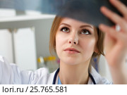 Young female doctor looking at lungs x-ray. Стоковое фото, фотограф Людмила Дутко / Фотобанк Лори