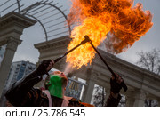 Мужчина выплевывает огненное пламя во время карнавального шествия в парке Сокольники города Москвы, Россия (2017 год). Редакционное фото, фотограф Николай Винокуров / Фотобанк Лори