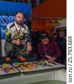 Moscow, Russia - February 25, 2017: Professional fisherman advertises wobblers and tackles on the special exhibition. Редакционное фото, фотограф Андрей Копылов / Фотобанк Лори