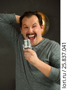 Outrageous man with mustache sing into microphone in studio with lamp on wall. Стоковое фото, фотограф Losevsky Pavel / Фотобанк Лори
