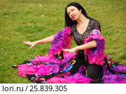 Young happy woman in beautiful skirt zingara poses on green lawn outdoor. Стоковое фото, фотограф Losevsky Pavel / Фотобанк Лори