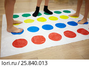 MOSCOW, RUSSIA - MAY 8, 2015: Children play Twister game in room. Twister is a game of physical skill produced by Milton Bradley Company and Winning Moves. Редакционное фото, фотограф Losevsky Pavel / Фотобанк Лори