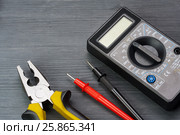 Multimeter and pliers on a dark wooden background. Стоковое фото, фотограф Alexander / Фотобанк Лори
