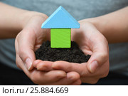 Female hands holding a piece of land with wooden house. Ecological home, construction and real estate concept. Стоковое фото, фотограф Сергей Дорошенко / Фотобанк Лори