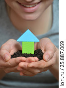 Female hands holding a piece of land with wooden house. Ecological home, construction and real estate concept. Стоковое фото, фотограф Сергей Дорошенко / Фотобанк Лори
