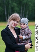 Young smiling woman holds little cute daughter outdoor at summer day, shallow dof. Стоковое фото, фотограф Светлана Додух / Фотобанк Лори