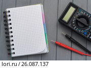 Multimeter on a wooden background next to an empty notepad. Empty space. Стоковое фото, фотограф Alexander / Фотобанк Лори
