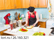 Домохозяйка на кухне пропитывает корж праздничного торта. Стоковое фото, фотограф Сергей Дубров / Фотобанк Лори