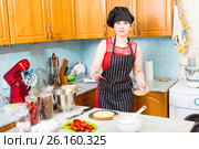 Хозяйка на кухне пропитывает корж праздничного торта с клубникой. Стоковое фото, фотограф Сергей Дубров / Фотобанк Лори