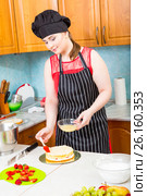 Девушка в кухонном фартуке и колпаке пропитывает кулинарной кистью корж для торта. Стоковое фото, фотограф Сергей Дубров / Фотобанк Лори