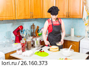 Хозяйка на кухне пропитывает верхний бисквит торта с помощью кулинарной кисточки. Стоковое фото, фотограф Сергей Дубров / Фотобанк Лори