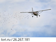 Легкий одномоторный самолет Cessna разбрасывает листовки над городом. Парад Победы, Пятигорск, Россия (2017 год). Редакционное фото, фотограф Александр Степанов / Фотобанк Лори