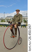 Велосипедист на старинном велосипеде на площади Революции, Москва. Penny Farthing Bicycle (велосипед паук) (2017 год). Редакционное фото, фотограф Валерия Попова / Фотобанк Лори