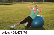 Sporty fit lady doing side crunches on ball. Стоковое видео, видеограф Швец Анастасия / Фотобанк Лори