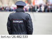 Полицейский в форме стоит спиной. Надпись "полиция" на куртке сзади. Стоковое фото, фотограф Кекяляйнен Андрей / Фотобанк Лори