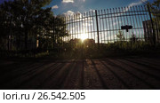 Sun through the fence. Стоковое видео, видеограф Потийко Сергей / Фотобанк Лори