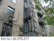 Монтаж шахты внешнего лифта на стене старого пятиэтажного трёхподъездного кирпичного жилого дома. Москва, улица Панфилова, 18а (2017 год). Стоковое фото, фотограф Александр Замараев / Фотобанк Лори