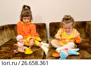 Две маленькие сестренки играют с куклами на диване. Стоковое фото, фотограф Ирина Борсученко / Фотобанк Лори